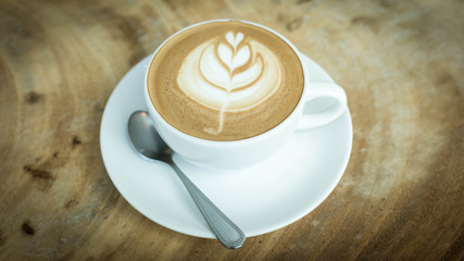 Hot art Latte Coffee in a cup on wooden table and Coffee shop bl
