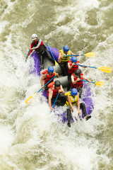 A thrilling summer adventure as a white water raft navigates through the rapids, splashing and carving through the rushing water.