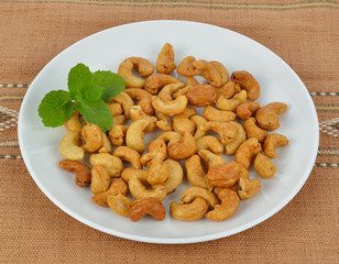 tasty cashew nuts with leaves in the dish on the mat