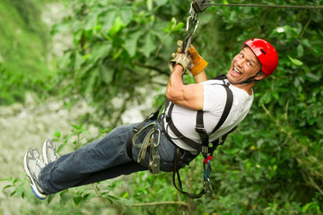 A man flying through the trees on a zipline, feeling the rush of adrenaline on an adventurous tour.