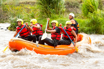 A team of adventurers navigate white water rapids on a thrilling rafting excursion, guided by an experienced instructor.