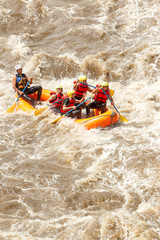 A diverse group of male and female tourists led by an experienced pilot embarking on an adventure through challenging rapids while river rafting in Ecuador