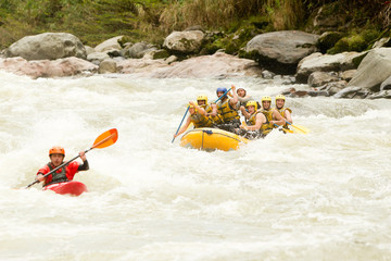 A group of kayakers navigating through white water rapids on a challenging outdoor rafting expedition.