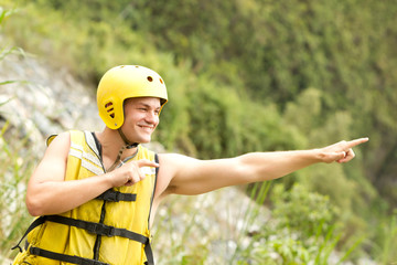 Sporty adult male in standard water sport attire gesturing towards the sky for an exhilarating...