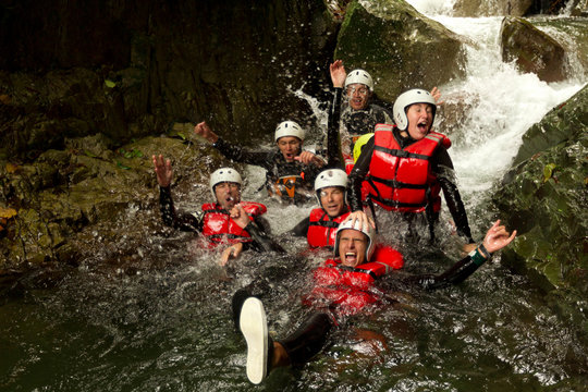 outdoor canyoning active group adventure water sport fun expedition river partnership of energetic teenage human during a canyoning expedition in ecuadorian rain forest outdoor canyoning active group