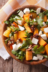 salad with persimmon, nuts, arugula and cheese closeup. vertical top view
