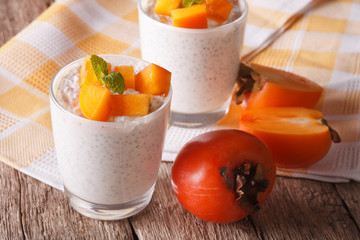Delicious breakfast: chia seed pudding and persimmon close up 
