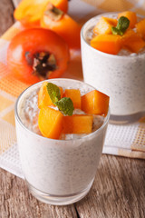 dessert with chia seeds and persimmon in a glass. vertical
