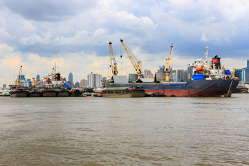 Bulk cargo ship unloading their cargo in the Chao Phraya River