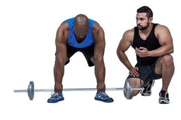 Fototapeta premium Man lifting barbell with trainer