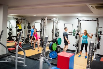 Fototapeta na wymiar Fit people working out in weights room