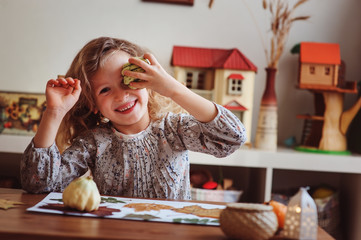 cute child girl making herbarium at home, autumn seasonal crafts