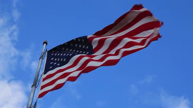 American flag waving against a blue Colorado sky
