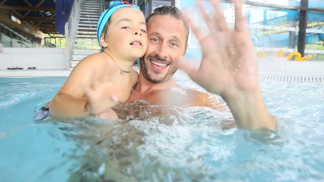 Daddy and son enjoying time at the swimming-pool