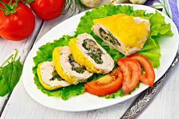 Roll chicken with spinach and tomatoes on light board