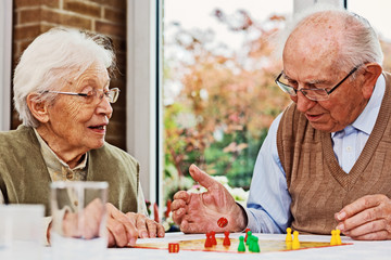Elderly couple and daughter, playing board game