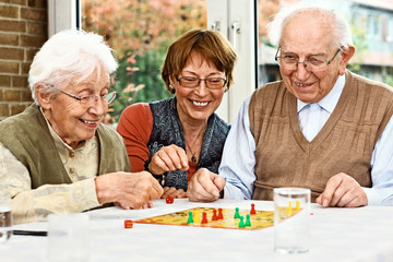 Elderly couple and daughter, playing board game