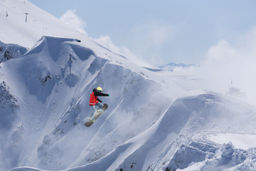Flying snowboarder on mountains