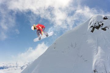 Flying snowboarder on mountains