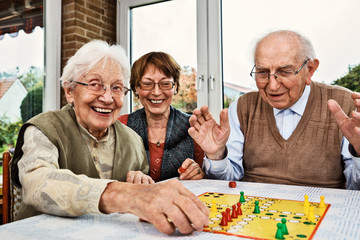 Elderly couple and daughter, playing board game
