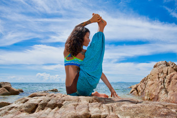 beautiful young woman doing yoga on the beach