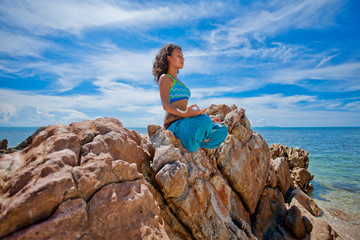 beautiful young woman doing yoga on the beach