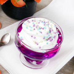 Colorful jelly with whipped cream and candy topping