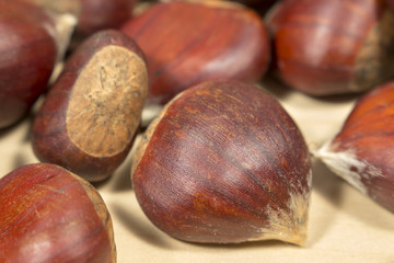 Several chestnuts on a wooden table