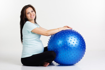 Pregnant woman exercising fitness with blue ball