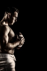 Composite image of shirtless american football player with ball