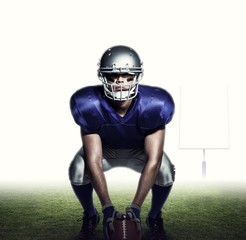 Composite image of american football player with ball crouching