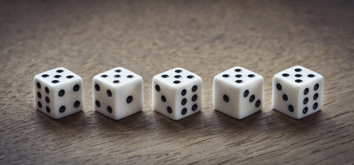Number five dice on wooden table