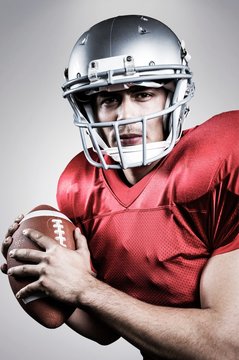 Portrait of serious american football player holding the ball