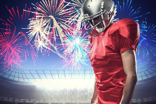 American football player looking down against firework