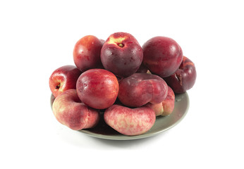 Fresh ripe red peaches with water drops on a ceramic plate isola