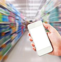 Female hand holding mobile smart phone on Supermarket blur background, business concept