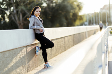 Beautiful woman resting in city after jogging