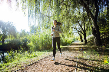 Fit beautiful woman jogging in park