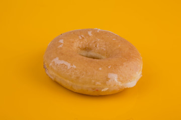 Glazed donut on yellow background
