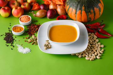 Pumpkin soup with onion and pepper on green shadowless backgroud