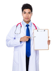 Doctor with pen point to clipboard