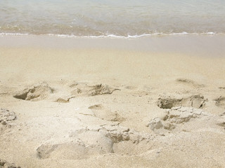Fototapeta na wymiar Sandy beach closeup with dry and wet sand near water edge.