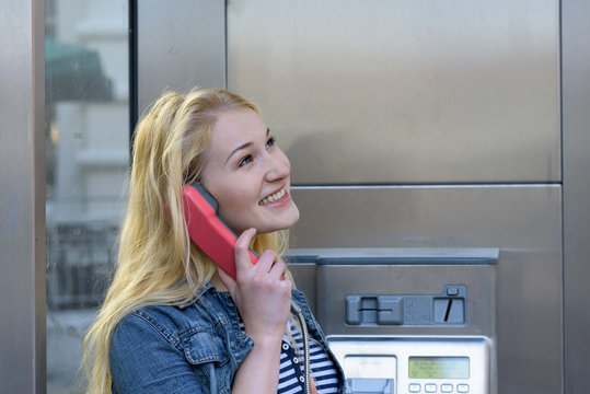 young blond woman in a phone booth