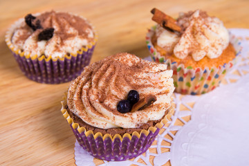 close up of cupcakes with cinnamon on wooden table