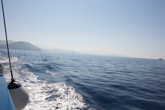 Seascape with water trail from boat with white ball fender