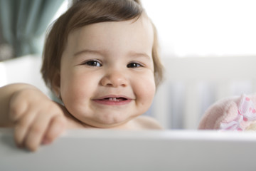 Infant baby resting and playing in his little baby bed