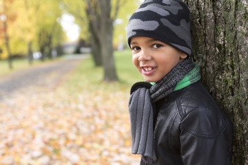 cute boy with autumn leaves in the park