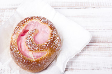 Sweet bun on white wooden background