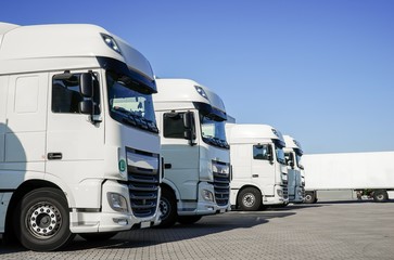 LKW-Spedition, mehrere abgestellte weiße LKW in einem Depot