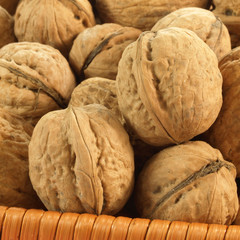 Closeup of walnuts in wicker basket, square